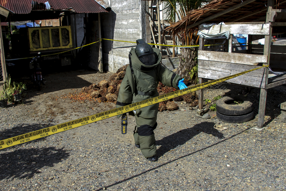An officer from the Aceh Police's bomb disposal unit sweeps the house of a local council member for explosives after a grenade attack on Monday. (Antara Photo/Syifa Yulinnas)