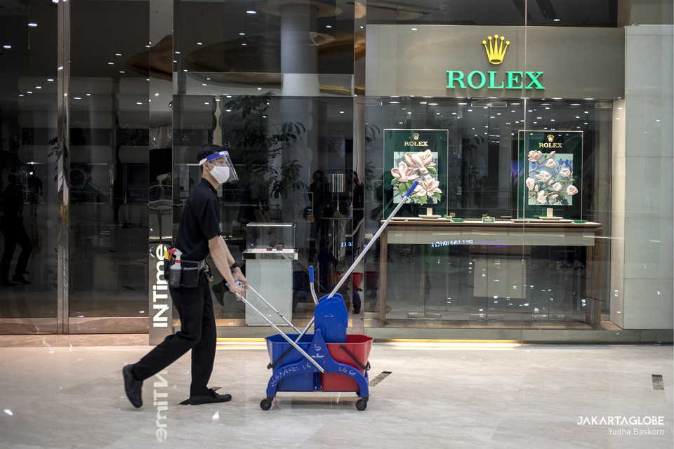 A janitor walks in front of a Rolex shop inside Senayan City mall in Central Jakarta. (JG Photo/Yudha Baskoro)
