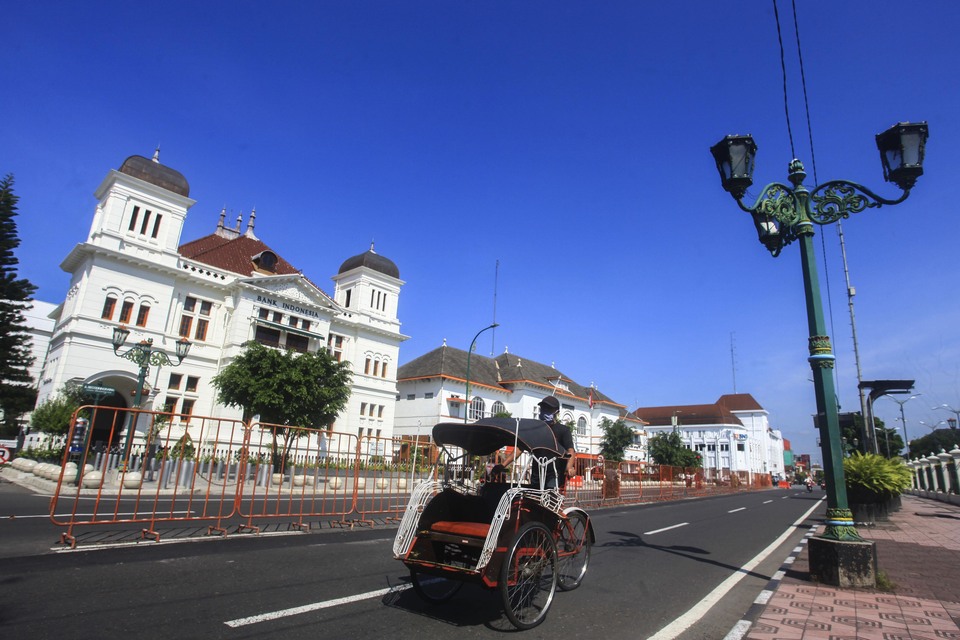 A rickshaw driver drives past a Dutch colonial architecture building in Yogyakarta on June 10, 2020. (Antara Photo/Andreas Fitri Atmoko)