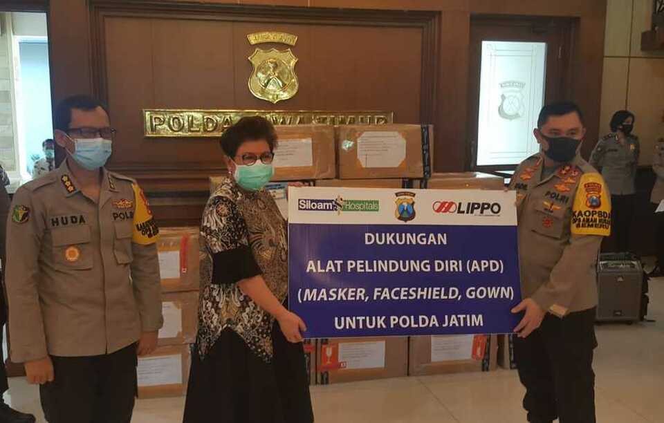Siloam Hospitals Surabaya's director and chief executive, Dr. Maria M. Padmidewi, hands over the donation to East Java Police Chief Insp. Gen. Muhammad Fadil Imran at the police headquarters in Surabaya on Thursday. (B1 Photo)
