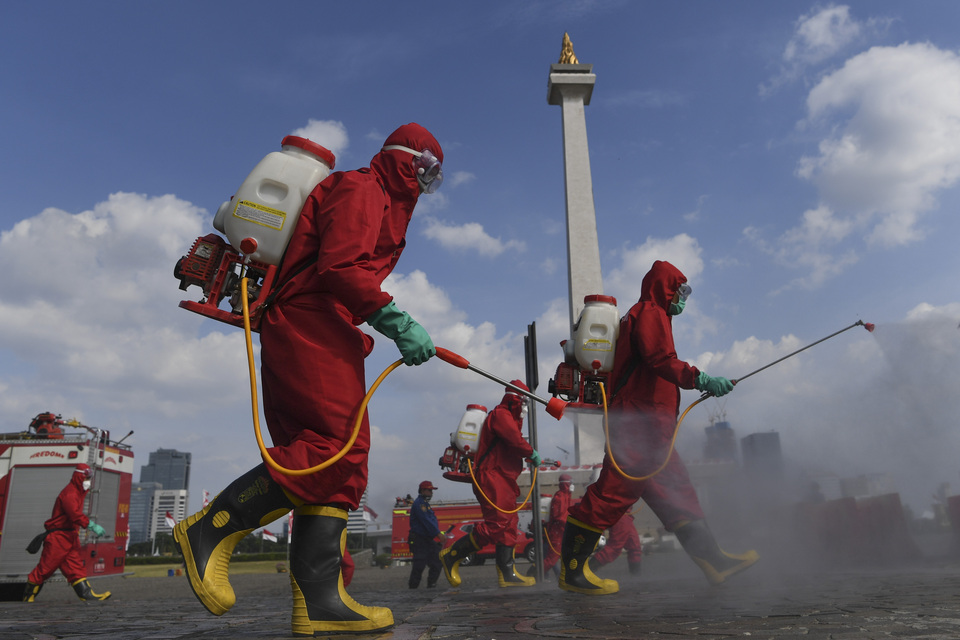 Firefighters disinfect the National Monument in Central Jakarta before it reopened last week. (Antara Photo/Wahyu Putro)