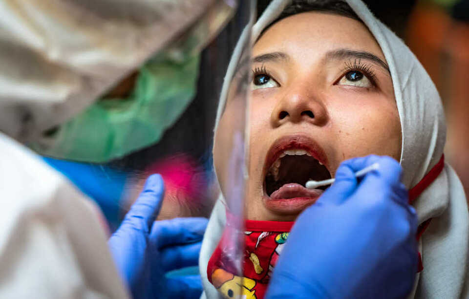 A health worker collects a throat swab from a woman in Semarang, Central Java, last month. (Antara Photo/e/Aji Styawan)