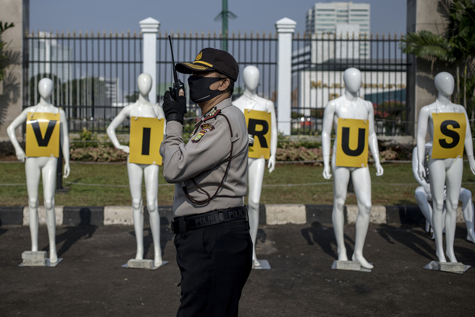 A policeman guards the Greenpeace mannequins in front of the House of Representatives in Jakarta on Monday. (JG Photo/Yudha Baskoro)