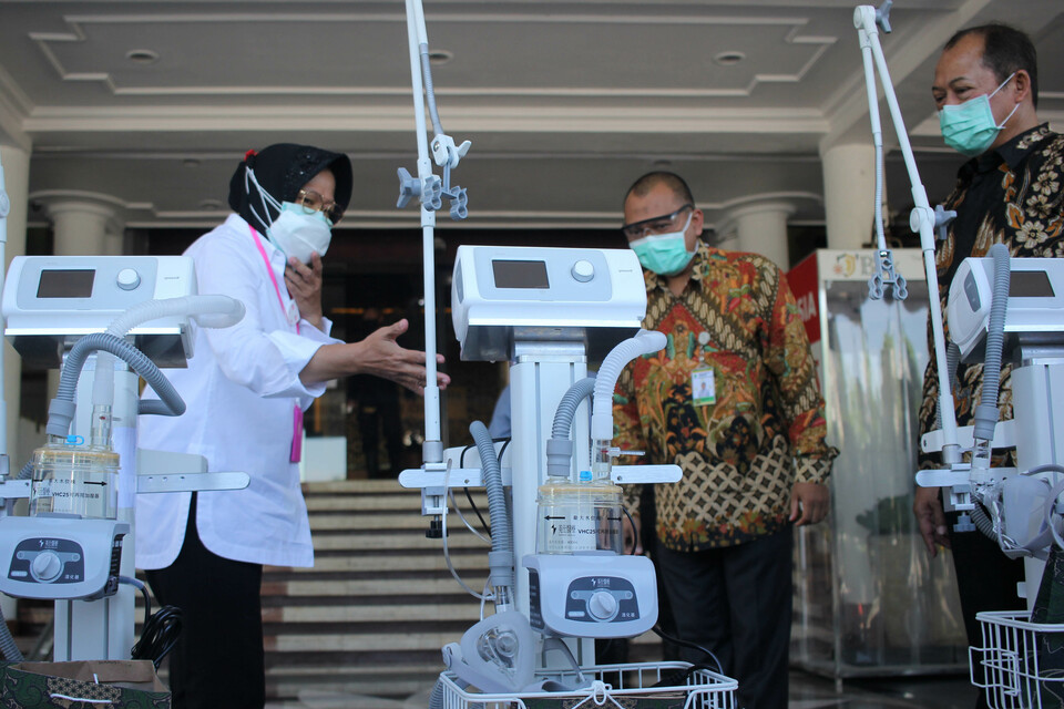 Surabaya Mayor Tri Rismaharini, left, gives away ventilators to hospital representatives in the East Java capital of Surabaya on June 30, 2020. The medical equipment assistance aims to upgrade hospitals’ capacity in handling Covid-19 patients. (Antara Photo/Didik Suhartono)