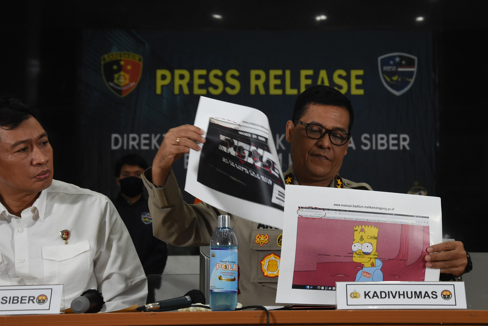 National Police spokesman Inp. Gen. Argo Yuwono, right, and cyber crime unit director Brig. Gen. Slamet Uliandi show evidence against a suspect in malware attacks on government websites during a news conference at the police headquarters in South Jakarta on July 7, 2020. (Antara Photo/Indrianto Eko Suwarso)