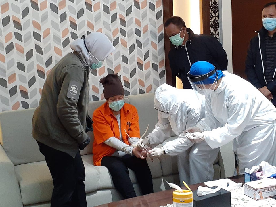 Medical workers take a blood sample from graft suspect Maria Pauline Lumowa for a rapid coronavirus testing upon her arrival at the Soekarno-Hatta Airport on July 9, 2020. (B1 Photo/Emral Firdiansyah)