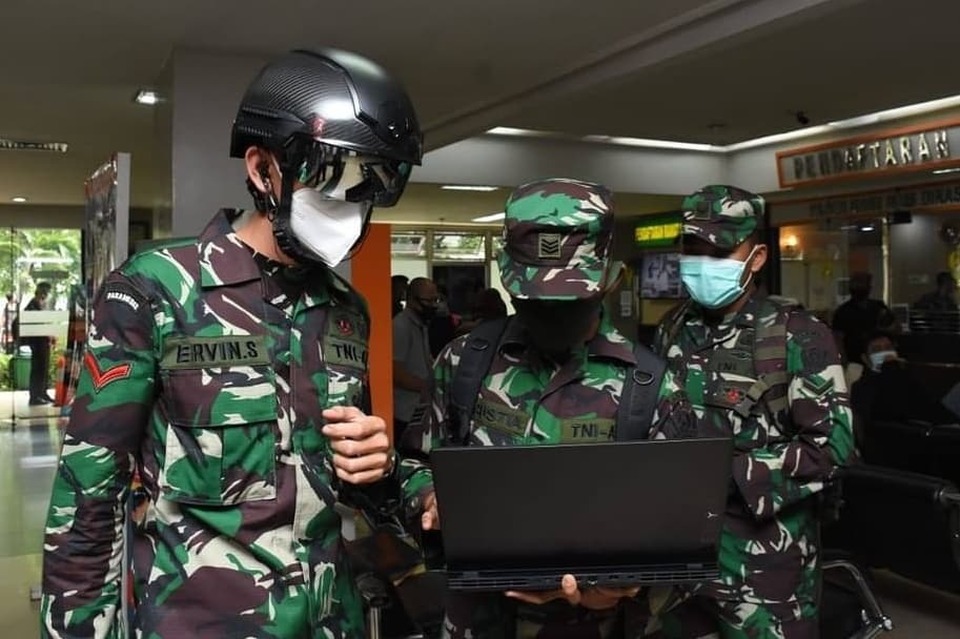 An Indonesian soldier wears a specially-designed helmet that can measure body temperature of another person within a 10-meter distance. (Photo courtesy of the Indonesian Military)