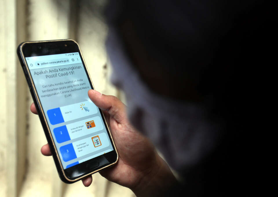 A Jakarta resident uses Corona Likelihood Metric (CLM) application on July 16, 2020. The app was introduced by the city government to allow residents to fill in their health data for monitoring. (B1 Photo/Joanito De Saojoao)