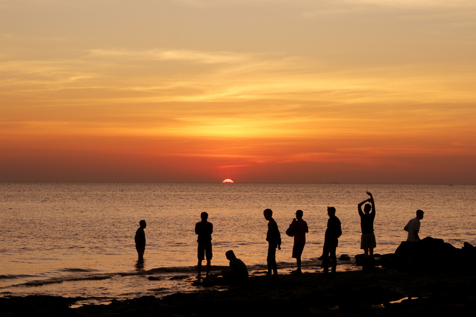 A group of men enjoys sunset at Kuri Caddi beach in Maros, South Sulawesi on Sunday. (Antara Photo/Arnas Padda)
