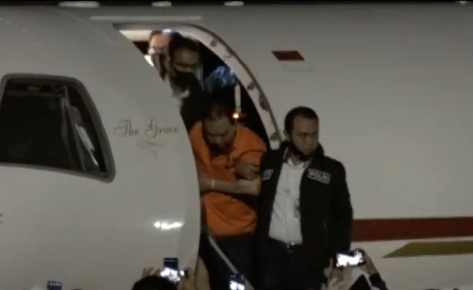 Graft fugitive Djoko Tjandra, left, walks out of a chartered plane at the Halim Perdanakusumah Airport in East Jakarta after a flight from Kuala Lumpur on July 30, 2020. (Beritasatu Photo/Emral Firdiansyah)
