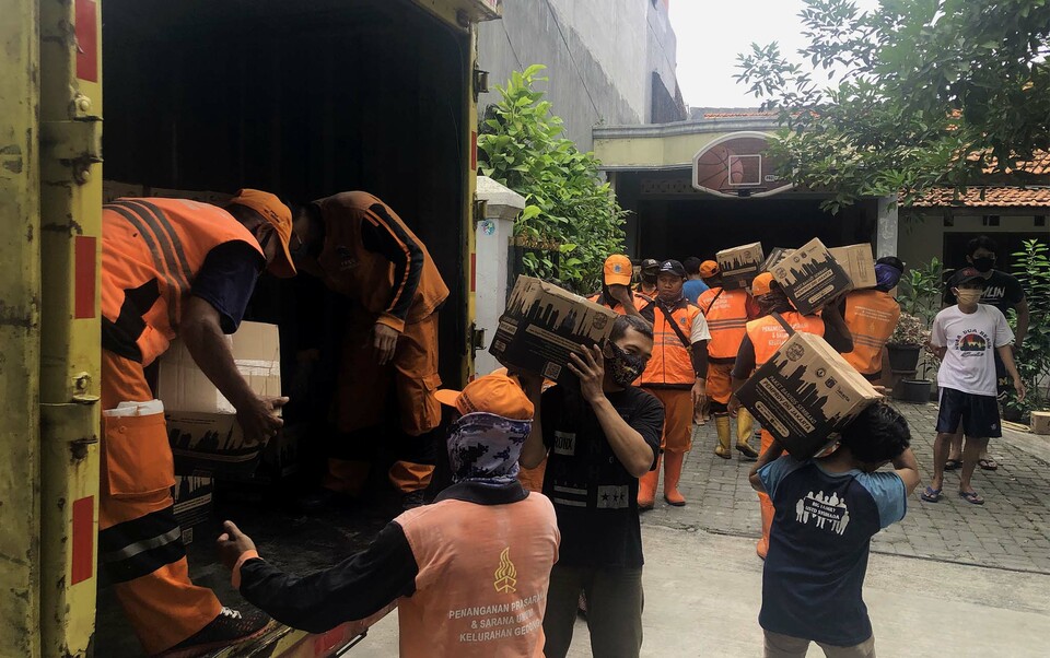 Workers unload boxes of basic supplies to be distributed among poor families in Pasar Rebo, East Jakarta, on Aug. 2, 2020. The social aid packages were provided by the Jakarta Provincial Government and the Social Affairs Ministry for around 2.4 million poor families suferring from the economic impacts of the Covid-19 pandemic in the capital. (Beritasatu Photo/Joanito De Saojoao)