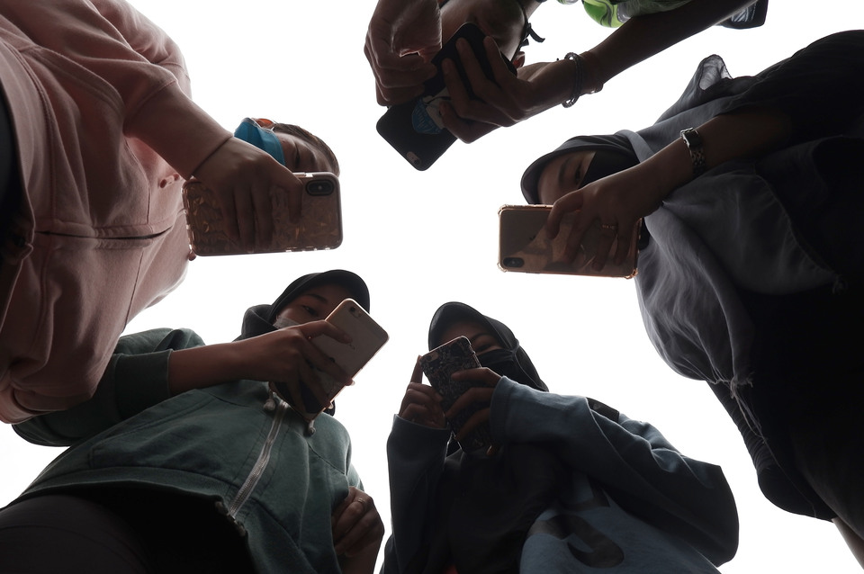 A group of teenagers playing with their phones in Medan, North Sumatera, last April. (Antara Photo/Septianda Perdana)
