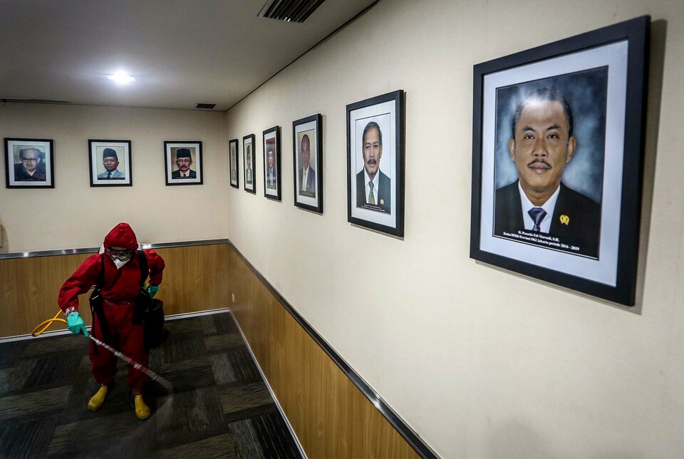 A medical staff sprays disinfectant at a room in the Jakarta Legislative Council building on July 29, 2020, after a councilor tested positive for coronavirus.(Beritasatu Photo/Joanito De Saojoao)