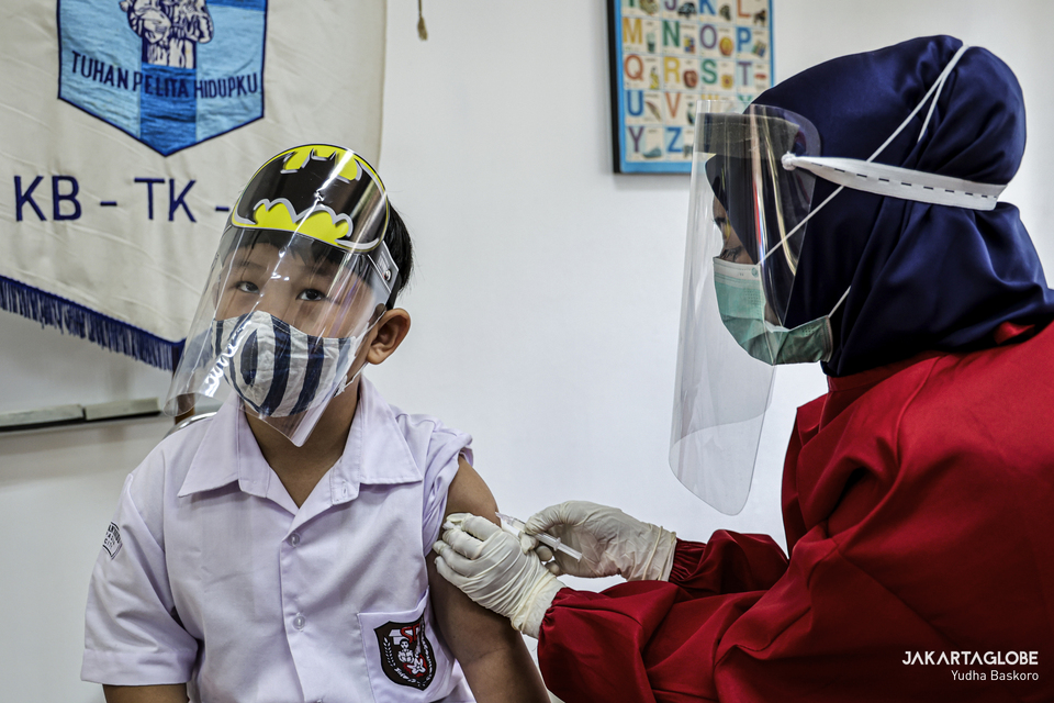 A student in health mask and face shield receives a missile vaccination in Santo Antonius Dari Padua Elementary School in Serpong, South Tangerang on Monday. (JG Photo/Yudha Baskoro)