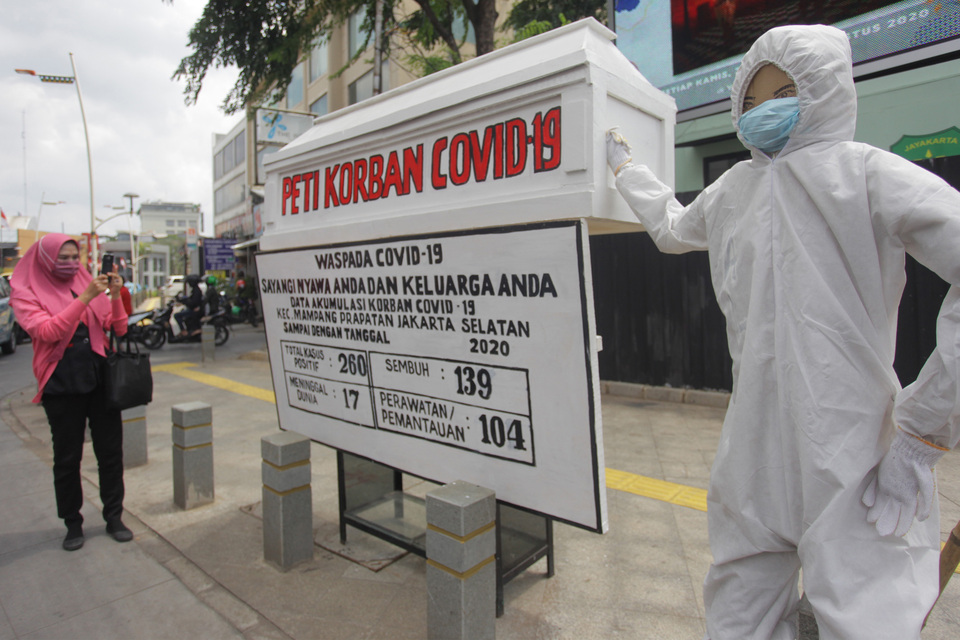 A board carrying updates on the city Covid-19 statistics is displayed in Kemang, South Jakarta, to raise public awareness about the outbreak. (Antara Photo /Reno Esnir)