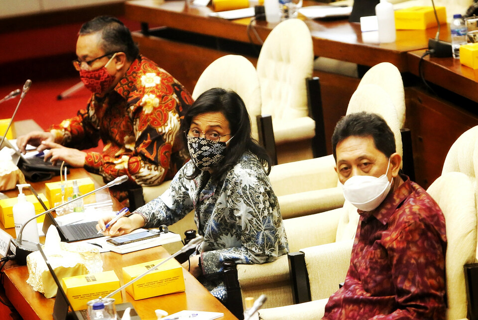 Finance Minister Sri Mulyani Indrawati, center, Bank Indonesia Governor Perry Warjiyo, left, and Heru Kristiyana, the Financial Services Authority's deputy chairman for bank supervision, attend a meeting with lawmakers at the House of Representatives on Monday. (B1 Photo/Ruht Semiono)