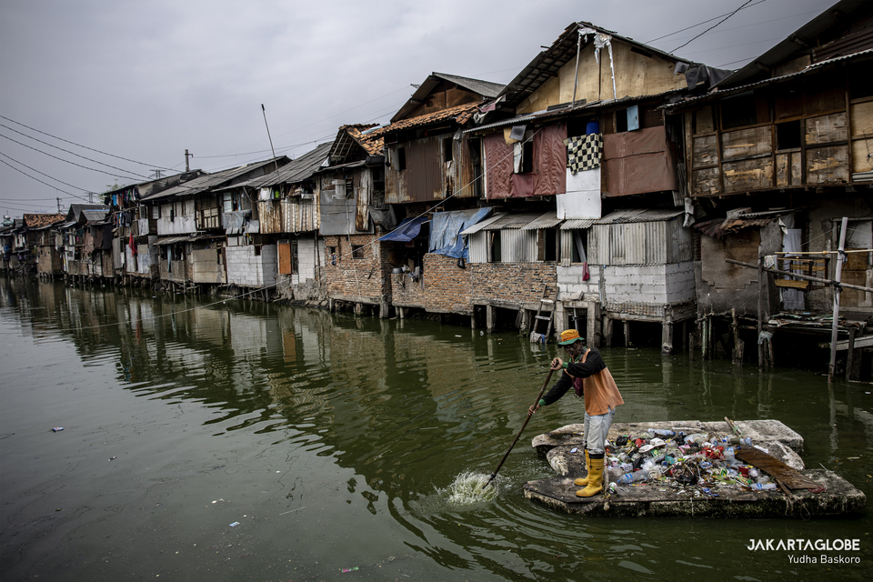 A worker collects trash on a river in Tanjung Selor, Central Jakarta,  on August 24, 2020. (JG Photo/Yudha Baskoro)