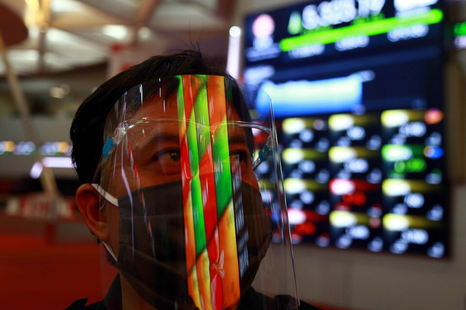 A man wearing a mask and face shield looks at monitors at Indonesia Stock Exchange in Jakarta last Thursday. (B1 Photo/Mohammad Defrizal)