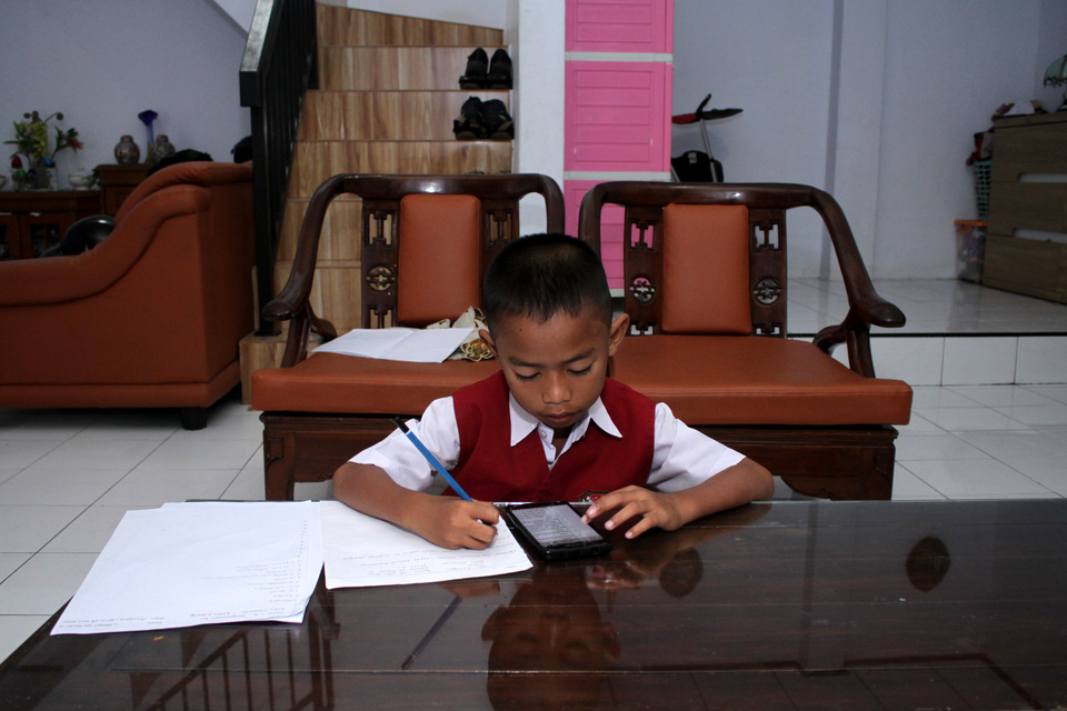 An elementary school student takes his online test from home in Makassar in June. (Antara Photo/Arnas Padda)