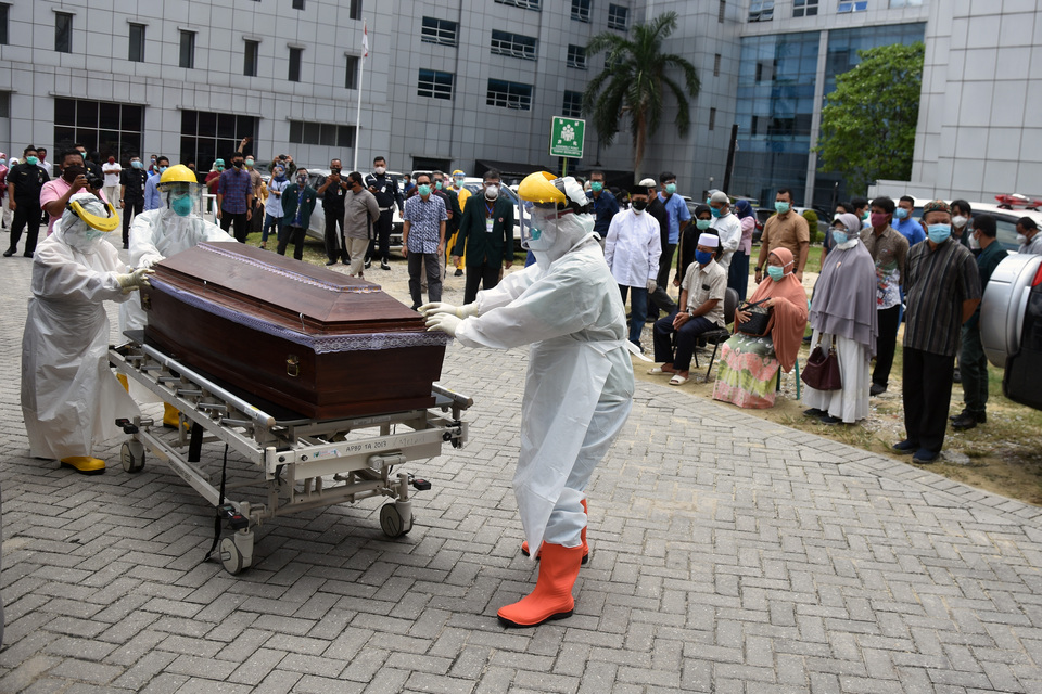 Medical workers carry the casket of Dr. Oki Alfin at Arifin Achmad Municipal Hospital in Pekanbaru, Riau, on Sept. 12, 2020. The doctor died from coronavirus-related disease after he was infected from a patient. (Antara Photo /FB Anggoro)