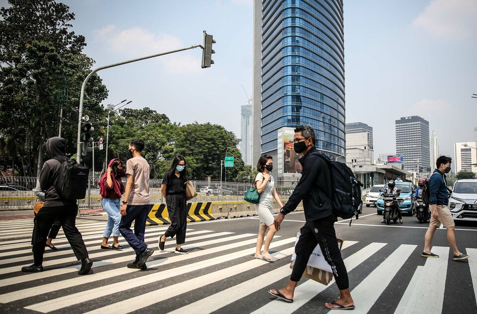 Office workers cross Jalan Thamrin, one of the main business streets in Central Jakarta, on Aug. 8, 2020. (SP Photo/Joanito De Saojoao)