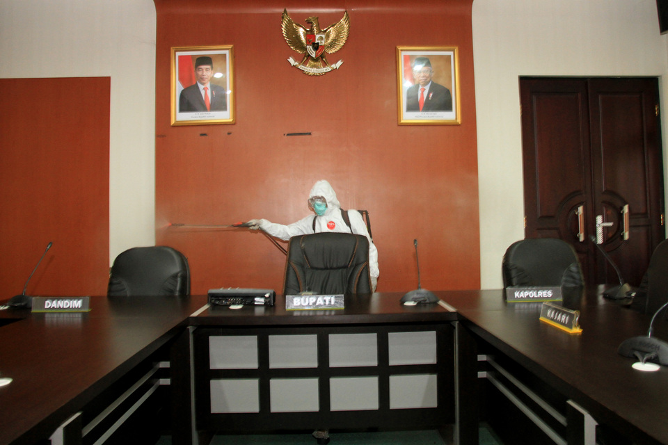 A medical worker sprays disinfectant at the office of West Aceh District head Ramli M.S. in Aceh on Sept. 20, 2020. The district head is suspected of contracting coronavirus after an earlier rapid diagnostic test. (Antara Photo/Syifa Yulinnas)
