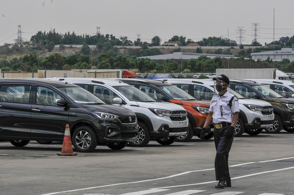 A security officer walks past several cars ready for sale at an industrial complex in Cikarang, West Java on Sep 4, 2020. (Antara Photo/ Fakhri Hermansyah)