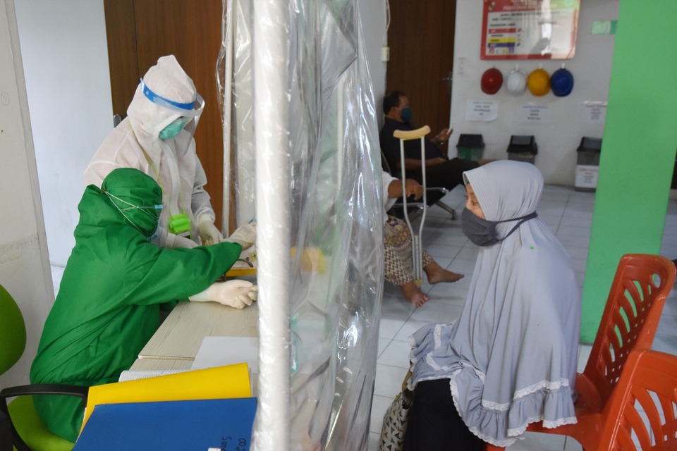 Hospital staffs wear protective suits as they serve a patient at a public health center, Puskesmas, in Pekanbaru, Riau, on Sept. 24, 2020. Riau has seen the highest surge in coronavirus cases among other Indonesian provinces in the month. (Antara Photo/FB Anggoro)
