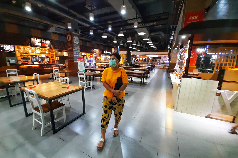 A woman walks in an empty food court in a shopping mall in South Tangerang last Thursday. (SP Photo/Ruht Semiono)
