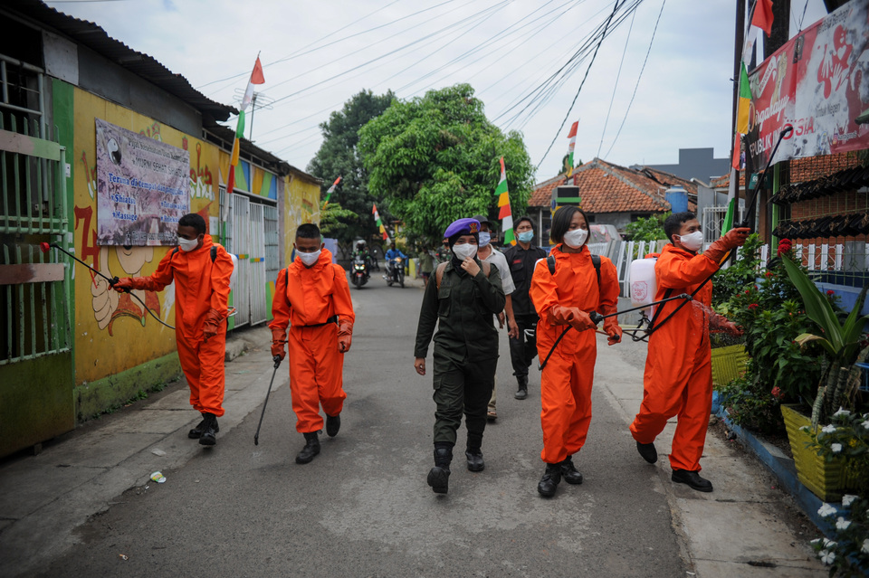 Military personnel and volunteers spray disinfectant around a densely-populated neighborhood on Jalan Gemuruh in the West Java capital Bandung. (Antara Photo/Raisan Al Farisi)