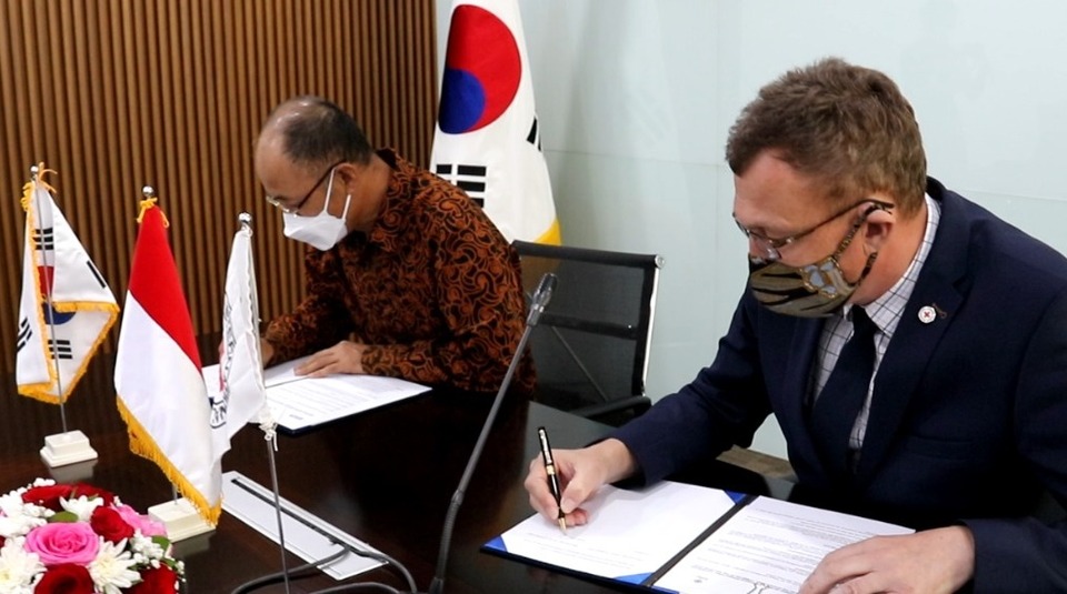 KOICA Indonesia country director Hoejin Jeong, left, signs agreement on $200,000 assistance to help Indonesia prevent the spread of Covid-19 among inmates in Jakarta on Oct. 7, 2020. 