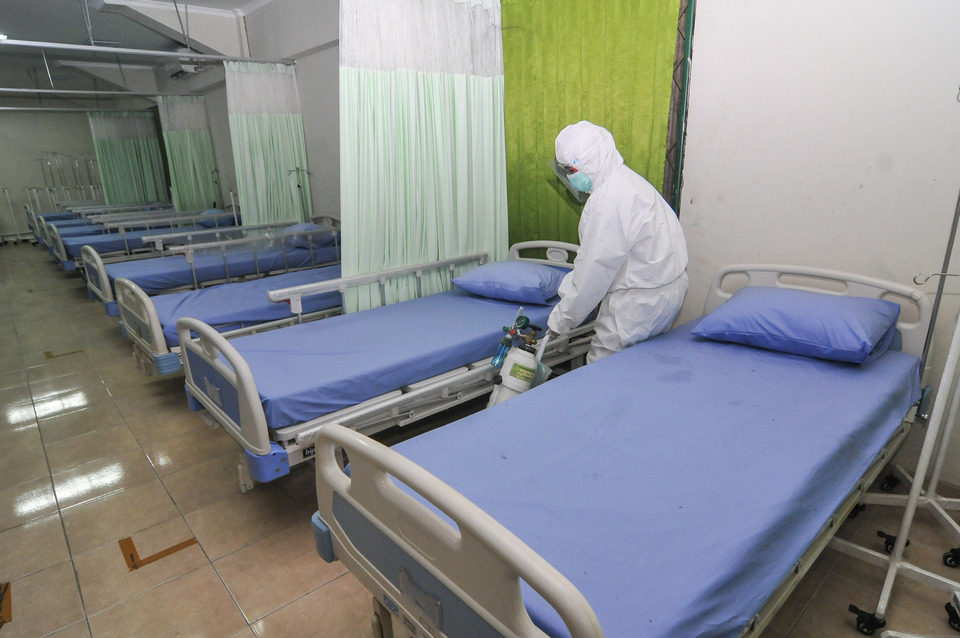 A medical staff sprays disinfectant in a makeshift isolation room for Covid-19 patients at the Patriot Chandrabhaga Stadium in Bekasi, West Java, on Sept. 9, 2020. (Antara Photo/Fakhri Hermansyah) 