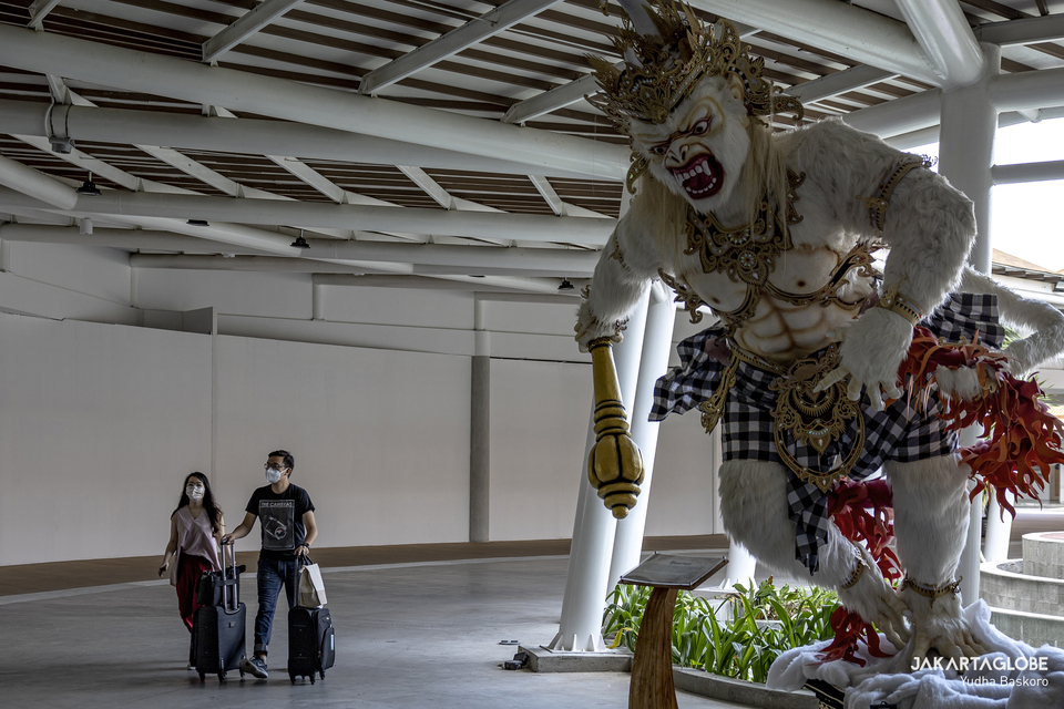 A couple walk near Hanoman statue in I Gusti Ngurah Rai airport in Bali on Monday (19/10). (JG Photo/Yudha Baskoro)