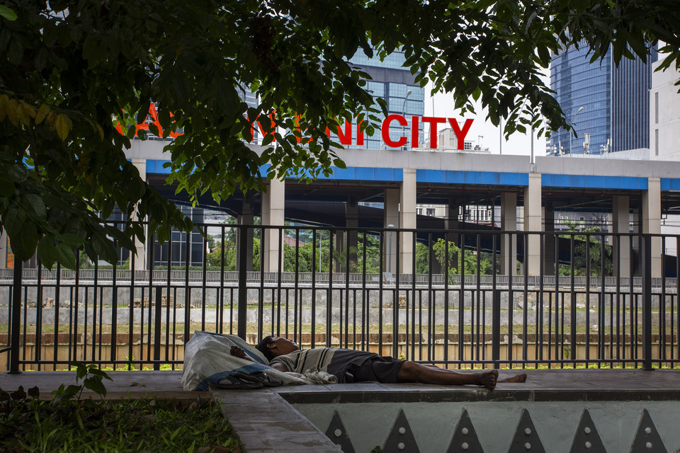 A man takes a nap across BNI City train station in Jalan Sudirman, South Jakarta on Wednesday. (Antara Photo/Dhemas Reviyanto)