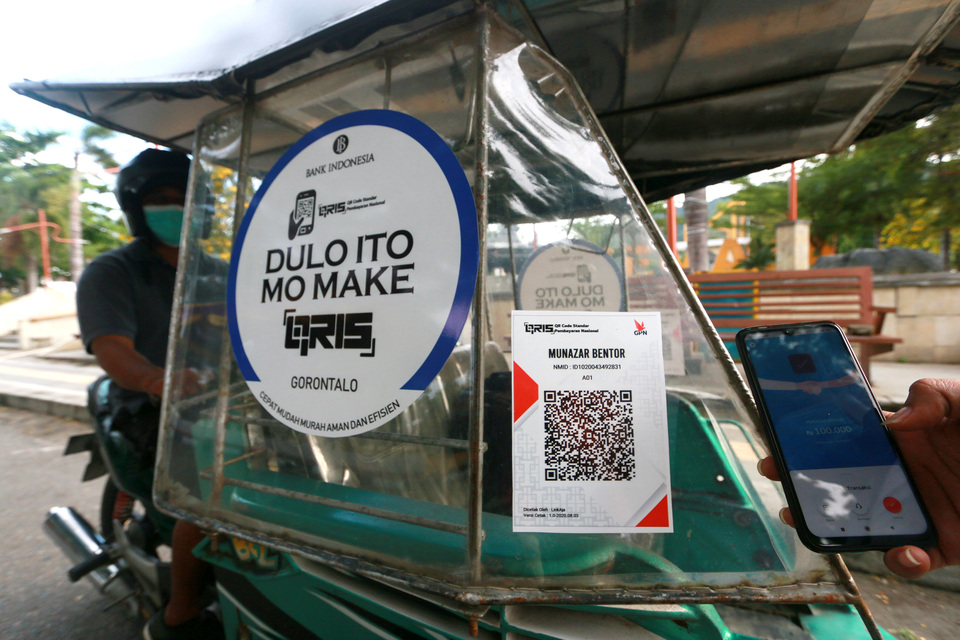 A motorized rickshaw accepts fare using a digital payment service in Gorontalo city, Gorontalo, on Sunday. (Antara Photo/Adiwinata Solihin)
