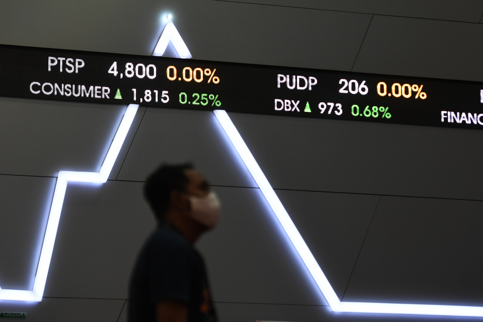 A man stands in front of a wall screen showing stock prices at the Indonesia Stock Exchange building in Jakarta on Oct 23, 2020. (Antara Photo/Hafidz Mubarak A.)