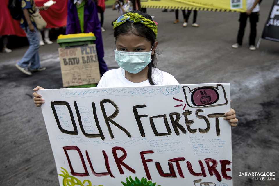 A child carries a placard during a climate crisis protest in front of ESDM building in Central Jakarta on Nov. 27, 2020 (JG Photo/Yudha Baskoro)