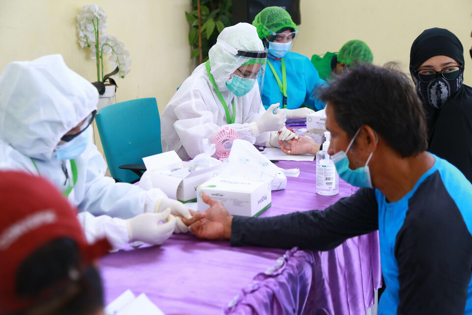 Medical workers take blood samples from election officials for rapid coronavirus diagnostic tests in South Tangerang, Banten, on Nov. 30, 2020, ahead of the December 9 local election. (BeritaSatu Photo/Mohammad Defrizal)