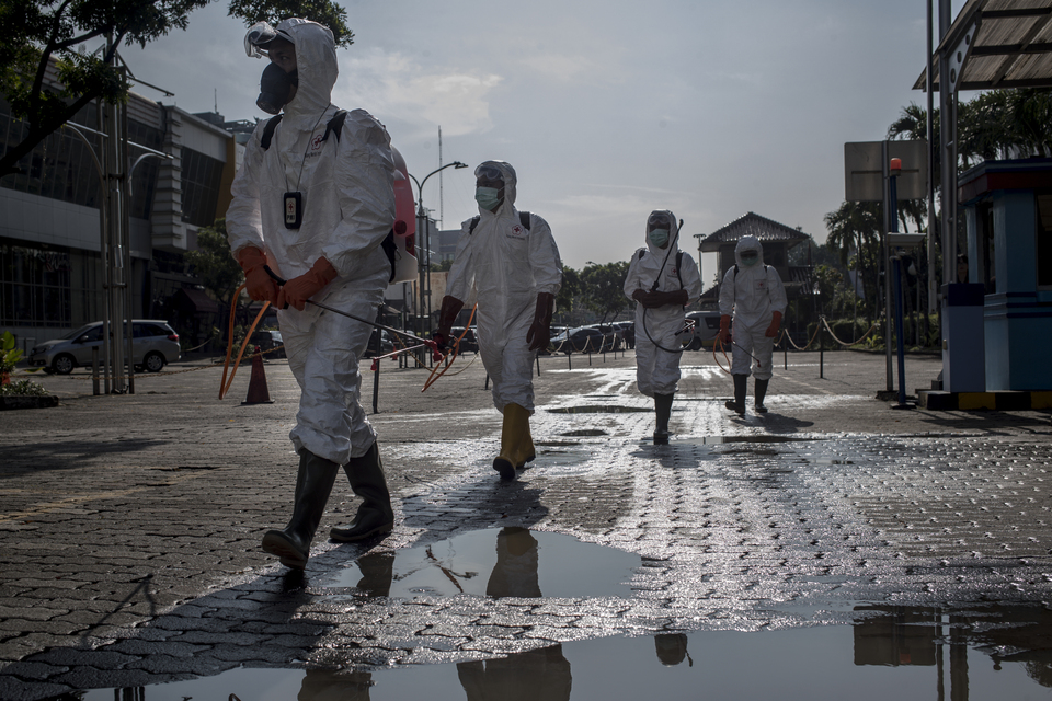 Indonesian Red Cross personnel wearing protective gear march to disinfect the Sarinah department store in Central Jakarta on March 18, 2020. (JG Photo/Yudha Baskoro)