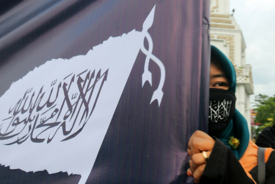 In this undated photo, a woman carries the flag of Hizbut Tahrir Indonesia. (Antara Photo)