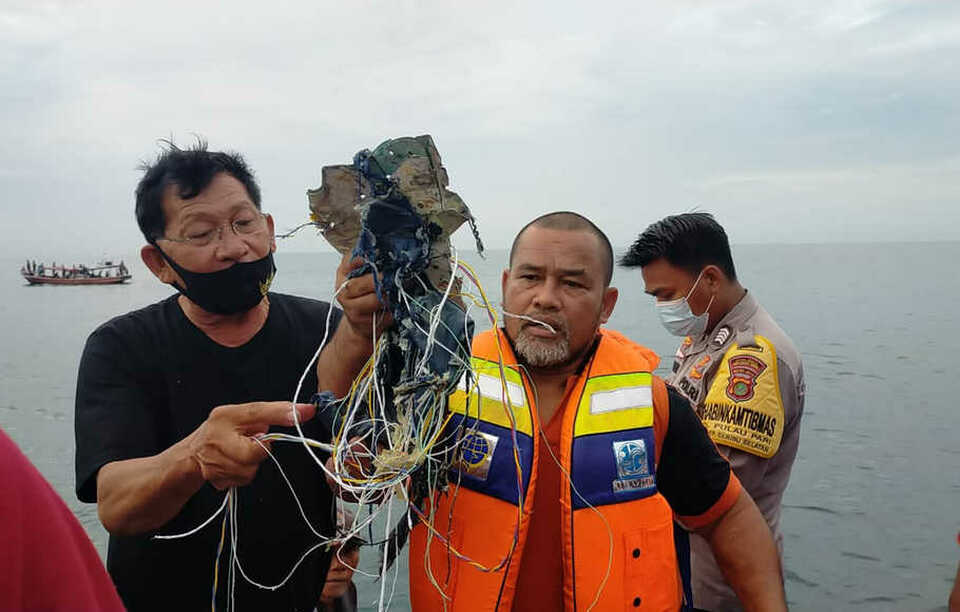 A man holds debris suspected of coming from Sriwijaya Air flight 182 that has lost contact above the sea near the Thousand Islands, off the coast north of Jakarta, on Saturday. (B1 Photo)