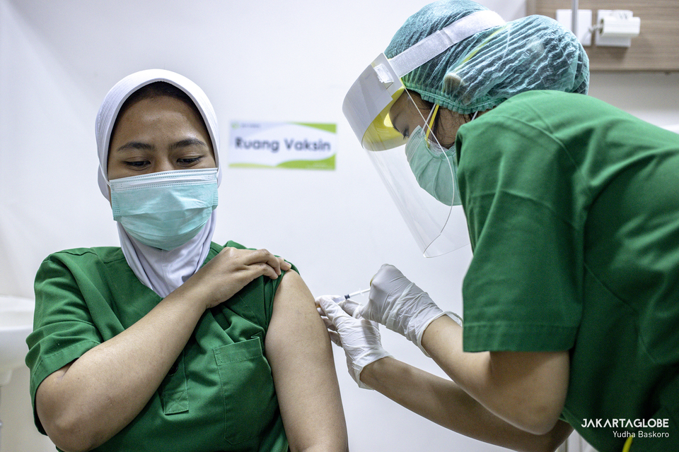 A health worker receives Covid-19 vaccine at a hospital in South Jakarta on Jan. 15, 2021. (JG Photo/Yudha Baskoro)