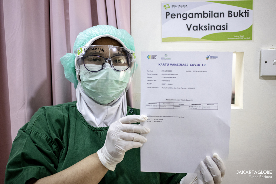 A health worker shows a Covid-19 vaccination form  at a hospital in South Jakarta on Jan. 15, 2021. (JG Photo/Yudha Baskoro)