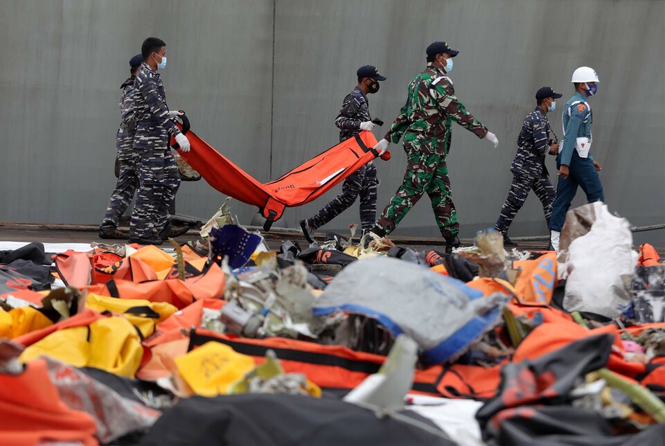 Indonesian Navy officers carry new findings of plane wreckages and human remains of the downed Sriwijaya Air SJ-182 at JICT II Tanjung Priok, North Jakarta, on Jan. 18, 2021. (SP Photo/Joanito De Saojoao)