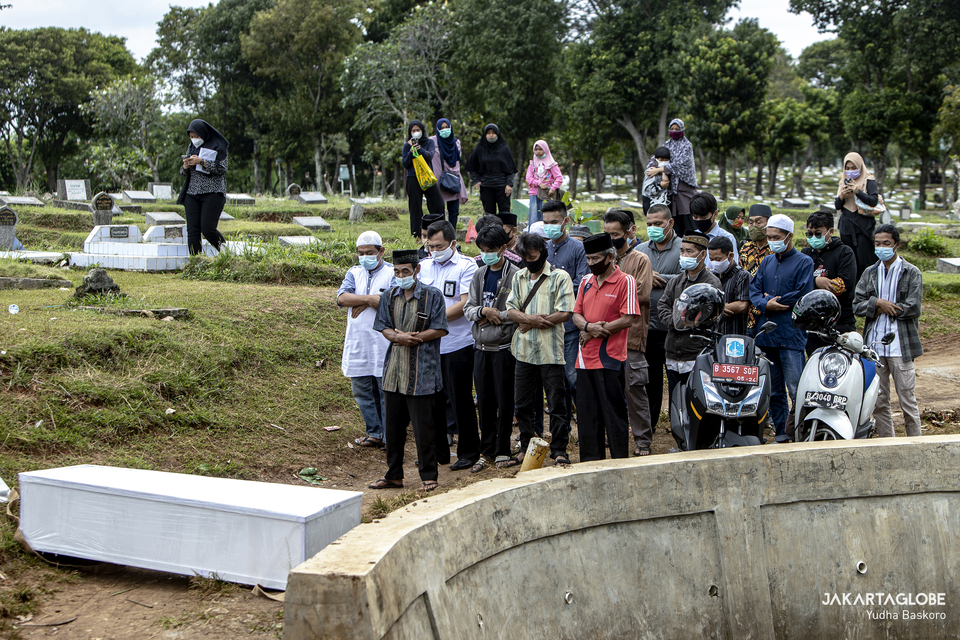 Mourners perform a prayer during the funeral of a deceased Covid-19 patient at Srengseng Sawah public cemetery in South Jakarta Jan. 26, 2021. (JG Photo/Yudha Baskoro)