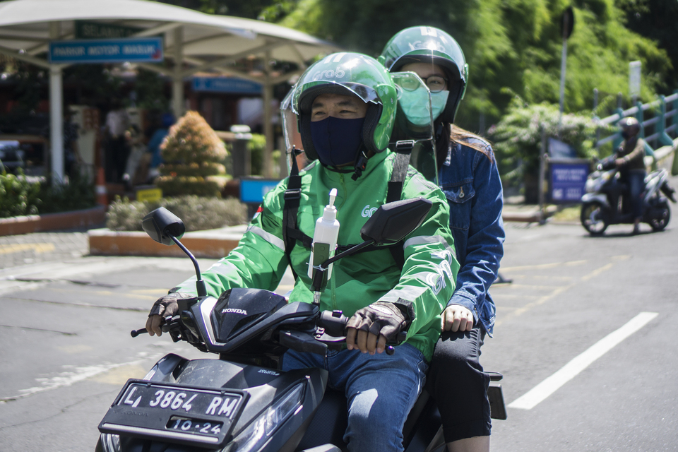 A GrabBike Protect driver drives a passenger to her destination. (Photo Courtesy of Grab)