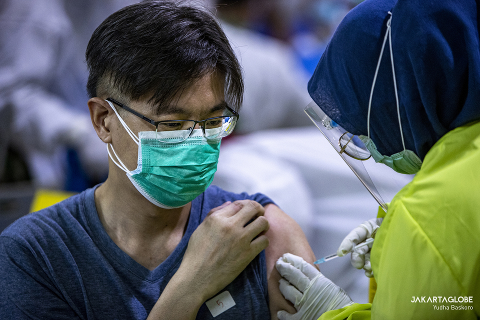 A man receives his first dose of Sinovac vaccine at Tanah Abang Market in Central Jakarta during mass Covid-19 vaccination drive on Feb. 17, 2021. (JG Photo/Yudha Baskoro)