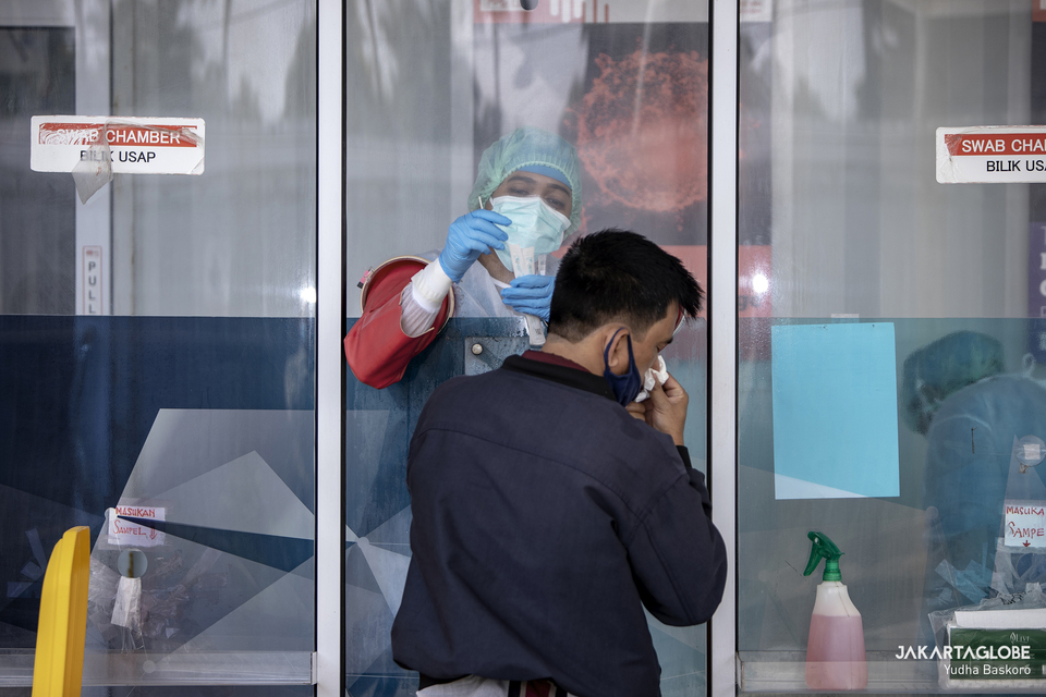 A health worker takes the specimen sample of man for coronavirus diagnostic test in Cilandak, South Jakarta on Feb. 23, 2021. (JG Photo/Yudha Baskoro)