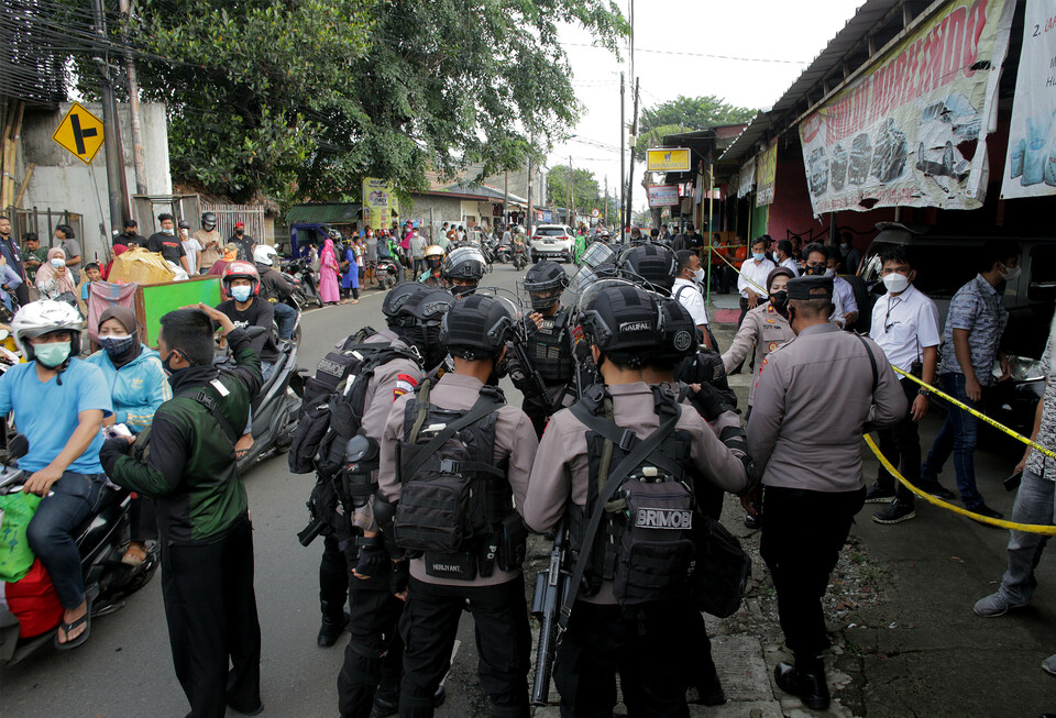 Jakarta Police officers stand guard near a house in Condet, East Jakarta, on March 29, 2021. Police raided the house and discovered explosive materials weighing 1.5 kilograms. (Beritasatu Photo/Joanito De Saojoao)