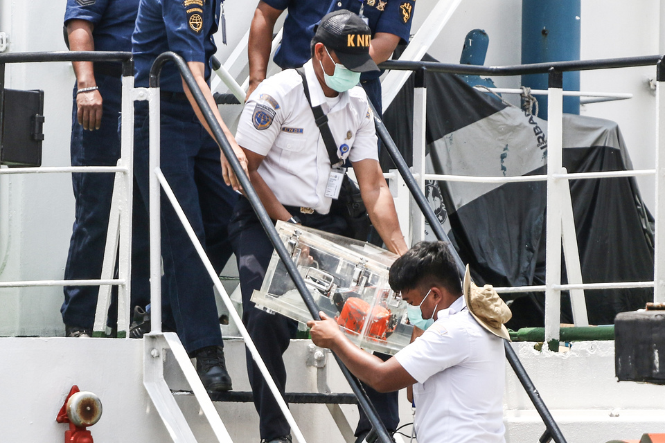 Officials from the National Transportation Safety Committee (KNKT) unload the cockpit voice recorder (CVR) of the ill-fated Sriwijaya Air Flight 182 from a transport ship docking at Tanjung Priok Port in Jakarta on Wednesday. (Antara Photo/Rivan Awal Lingga)